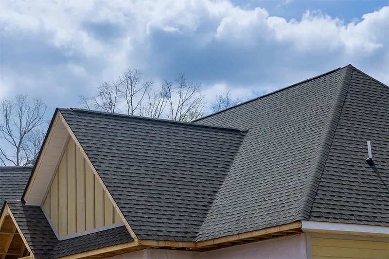 Dark gray architectural shingle hip roof with a board-and-batten gable