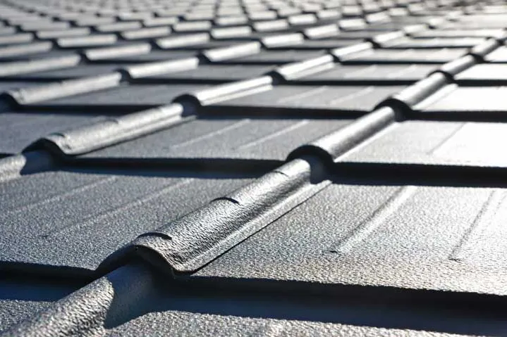 Close view of dark textured metal tile roofing