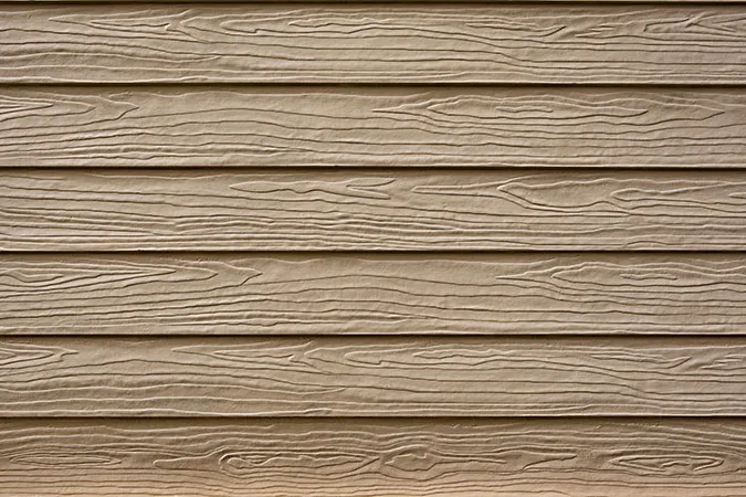 Close view of tan lap siding with a wood-grain texture